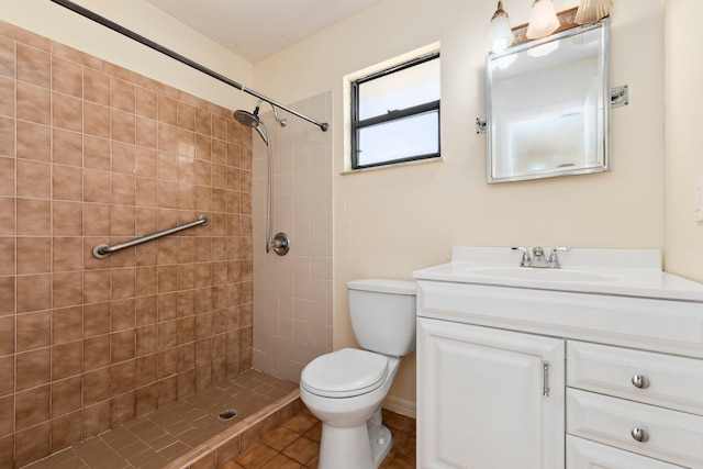 full bathroom featuring toilet, tiled shower, and vanity