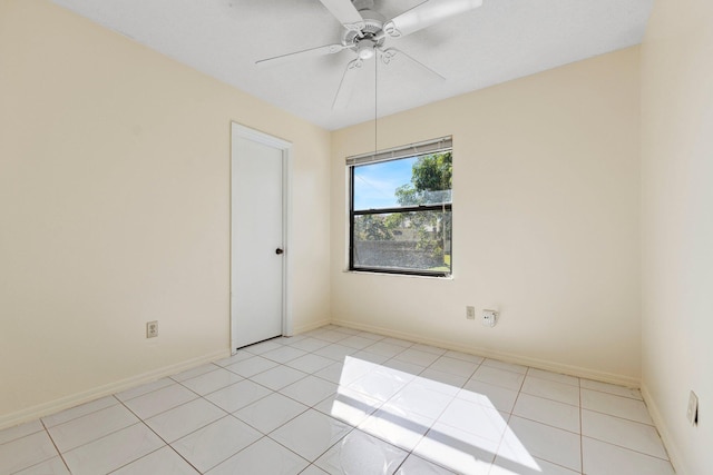 unfurnished room with ceiling fan, light tile patterned floors, and baseboards