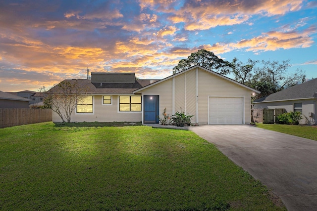 view of front of property featuring solar panels, concrete driveway, fence, a garage, and a front lawn