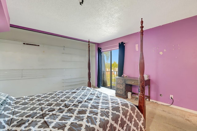 bedroom featuring access to outside, a textured ceiling, and baseboards