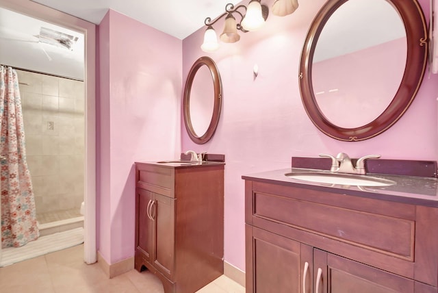 bathroom with tile patterned flooring, two vanities, a sink, baseboards, and a stall shower