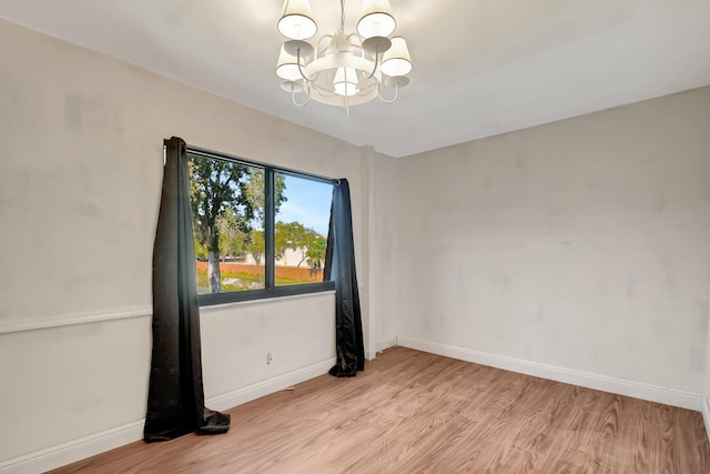 spare room featuring light wood-type flooring and baseboards