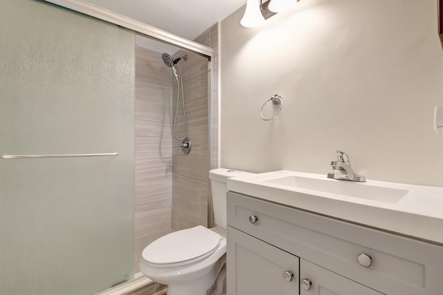 bathroom featuring a stall shower, vanity, and toilet