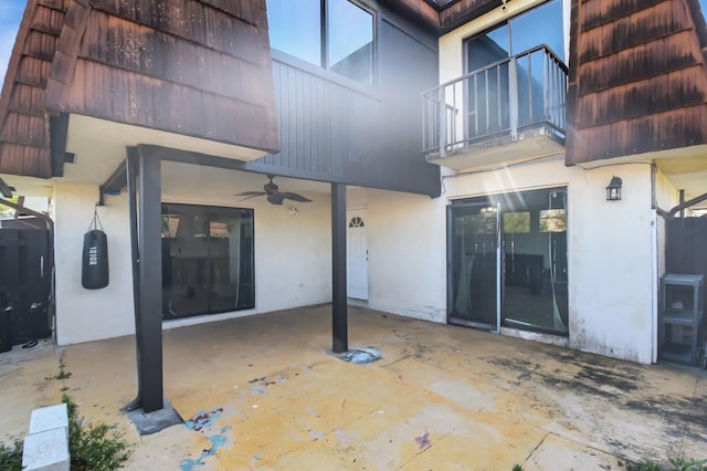 view of patio with ceiling fan and a balcony