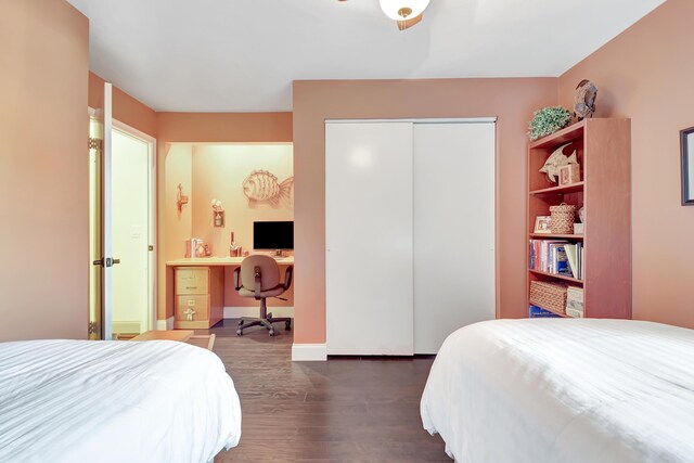 bedroom with dark wood-type flooring, a closet, and baseboards