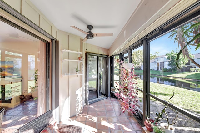 sunroom / solarium with a water view, plenty of natural light, and a ceiling fan