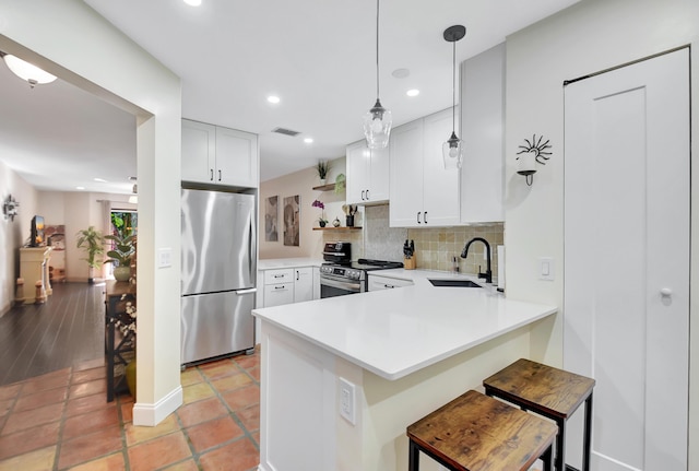 kitchen with visible vents, decorative backsplash, appliances with stainless steel finishes, a sink, and a peninsula