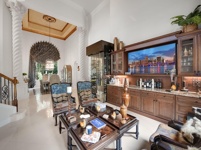 living room featuring crown molding, stairway, a high ceiling, a chandelier, and wet bar