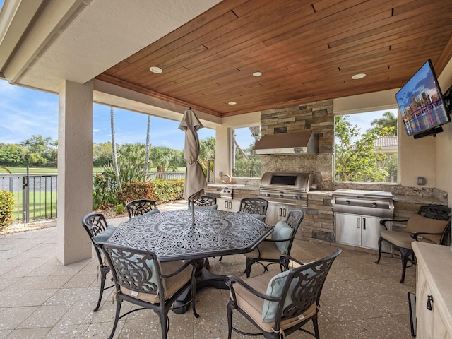 view of patio featuring outdoor dining area, an outdoor kitchen, a grill, and fence