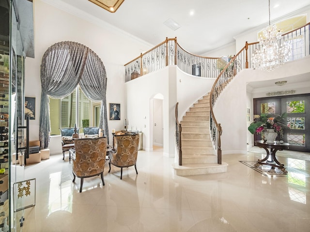 tiled entryway featuring arched walkways, a notable chandelier, a high ceiling, stairs, and ornamental molding