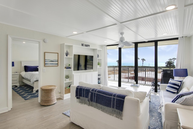 living area with light wood-style flooring, floor to ceiling windows, baseboards, and recessed lighting