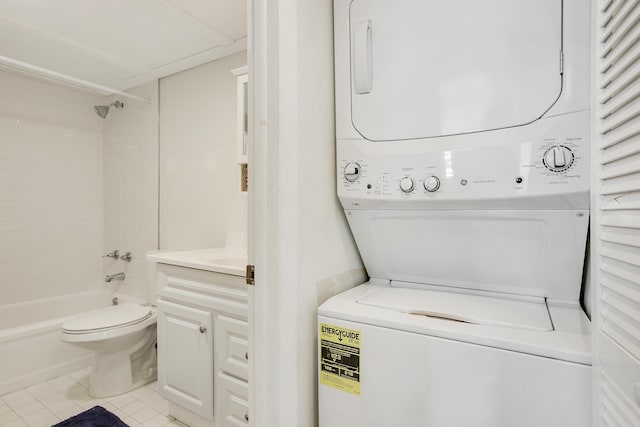 clothes washing area with laundry area, light tile patterned flooring, and stacked washing maching and dryer