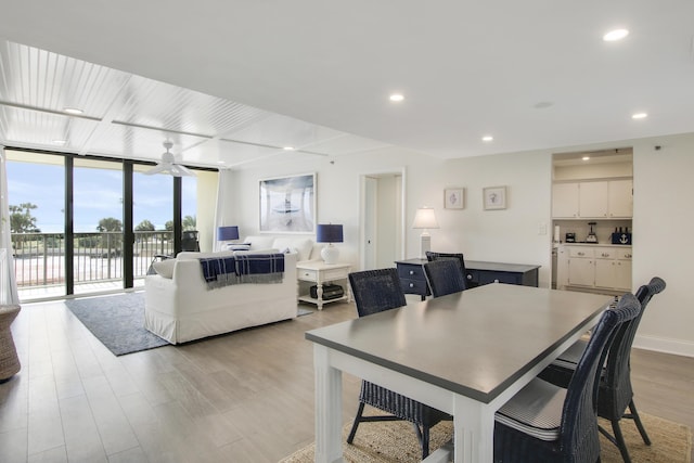 dining room with recessed lighting, a ceiling fan, baseboards, light wood-type flooring, and expansive windows