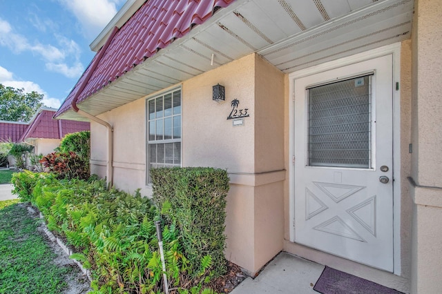 view of exterior entry with stucco siding