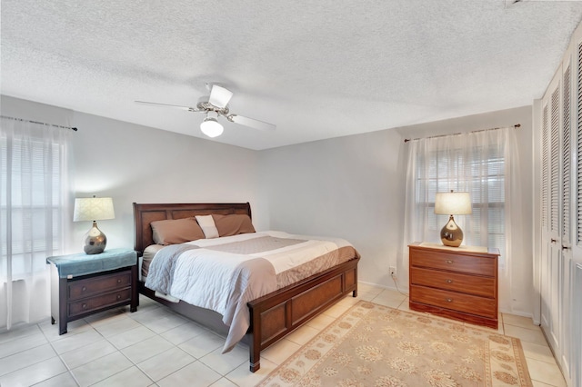 233 Down E Ln, Lake Worth, FL 33467 - bedroom featuring light tile patterned floors, a closet, a ceiling fan, a textured ceiling, and baseboards