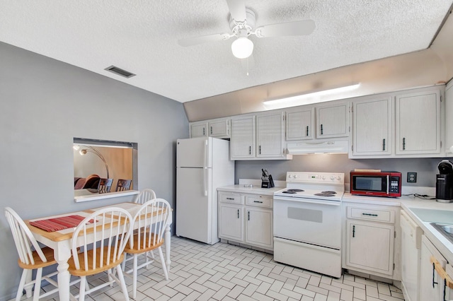 kitchen featuring light countertops, a ceiling fan, a textured ceiling, white appliances, and under cabinet range hood