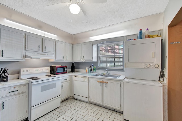 kitchen featuring under cabinet range hood, white appliances, a sink, light countertops, and stacked washer and clothes dryer