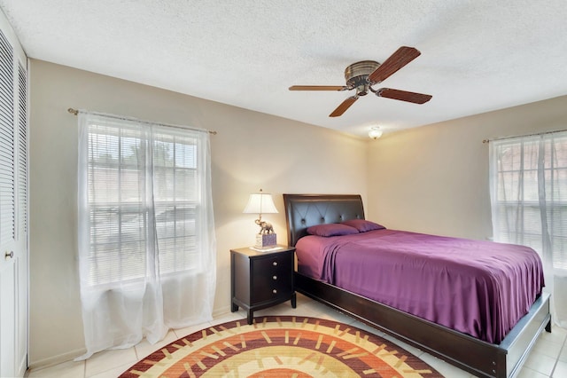 233 Down E Ln, Lake Worth, FL 33467 - bedroom featuring tile patterned floors, a ceiling fan, a closet, a textured ceiling, and baseboards