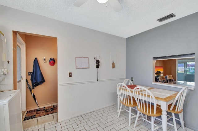 dining space with stacked washer and dryer, visible vents, ceiling fan, a textured ceiling, and baseboards