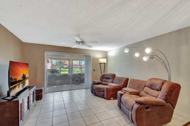 living room featuring ceiling fan, a textured ceiling, and light tile patterned floors