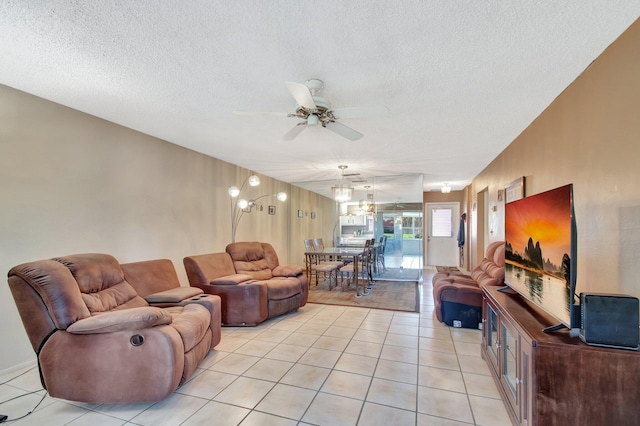 living area featuring light tile patterned floors, ceiling fan, and a textured ceiling