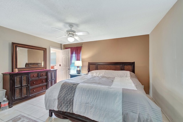 bedroom with a ceiling fan, light tile patterned flooring, and a textured ceiling