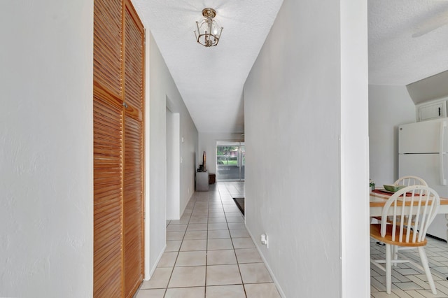 233 Down E Ln, Lake Worth, FL 33467 - corridor featuring light tile patterned floors, a textured ceiling, and baseboards