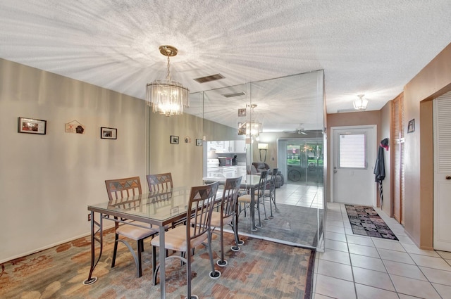 dining area with a textured ceiling, ceiling fan with notable chandelier, tile patterned flooring, and visible vents