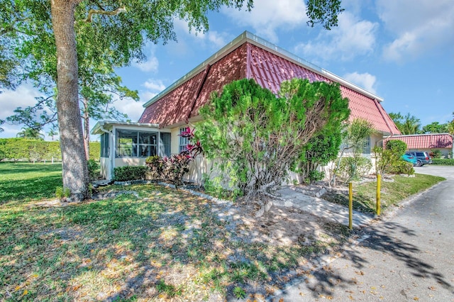 233 Down E Ln, Lake Worth, FL 33467 - view of front facade featuring a sunroom and a front yard