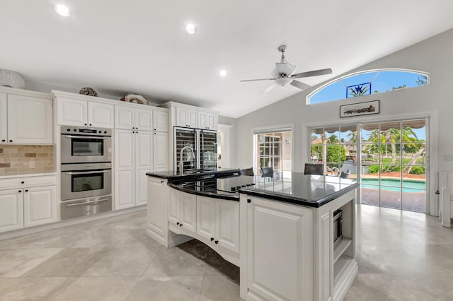 kitchen featuring lofted ceiling, double oven, white cabinets, a warming drawer, and refrigerator with glass door