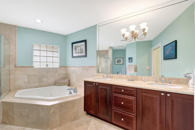 bathroom featuring a chandelier, double vanity, a sink, and a bath