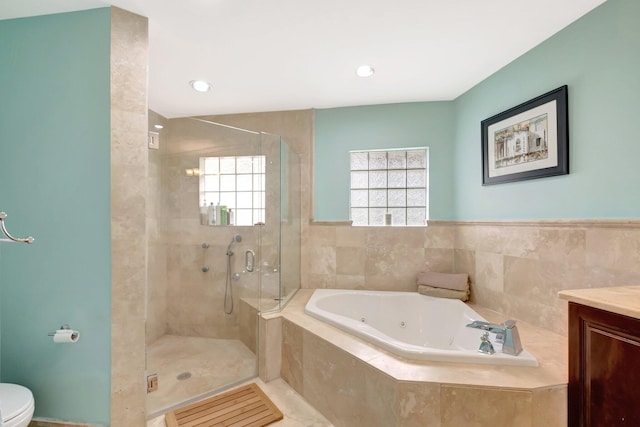 bathroom with vanity, a jetted tub, a shower stall, and toilet