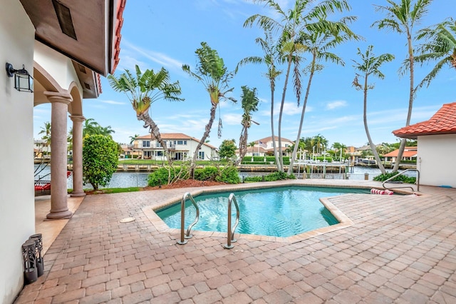 outdoor pool featuring a water view, a patio area, and a residential view