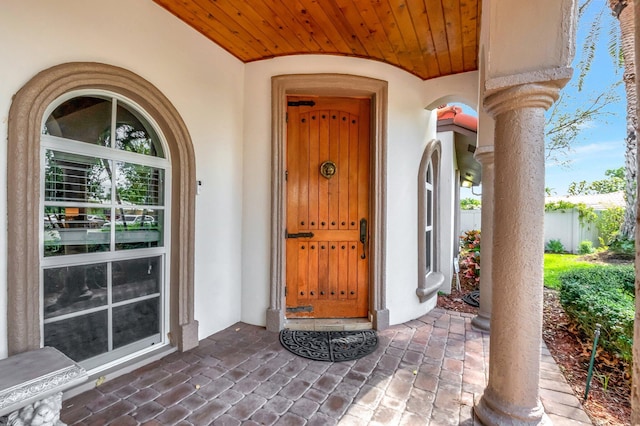 doorway to property featuring stucco siding