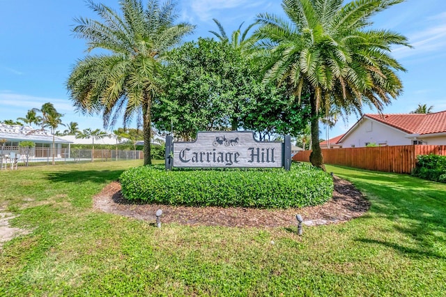 community sign with fence and a lawn