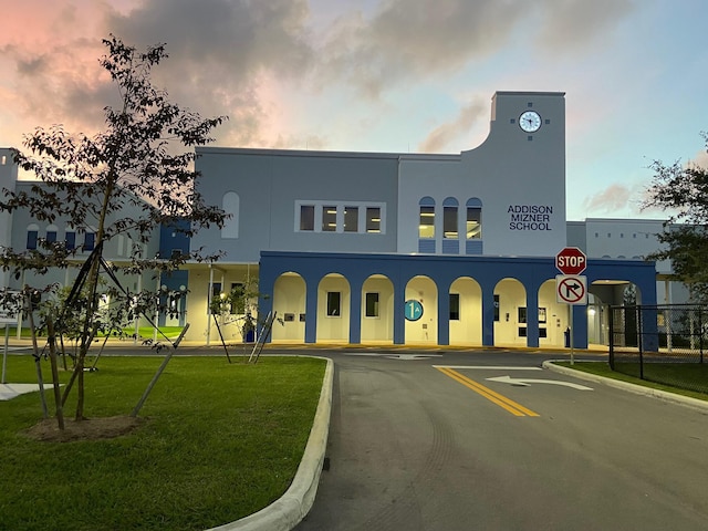 property at dusk featuring uncovered parking