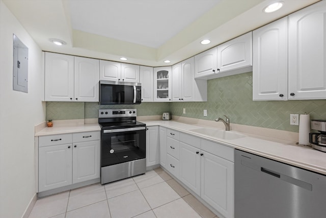 kitchen featuring electric panel, appliances with stainless steel finishes, white cabinets, and a sink