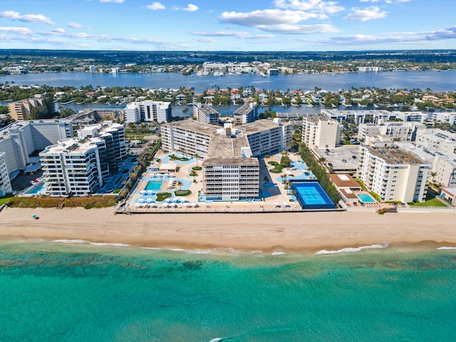 drone / aerial view featuring a water view, a view of city, and a beach view