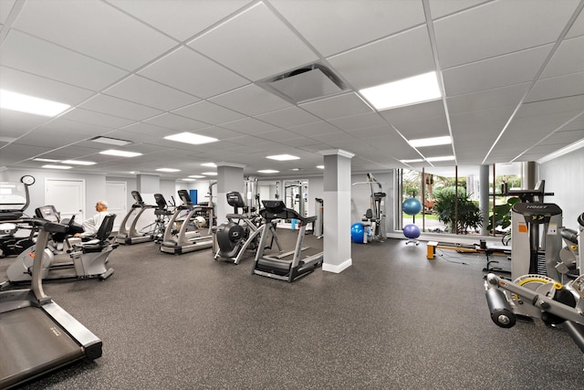 exercise room with a paneled ceiling and visible vents