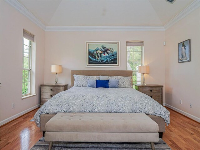 bedroom featuring light wood-style floors, lofted ceiling, and multiple windows