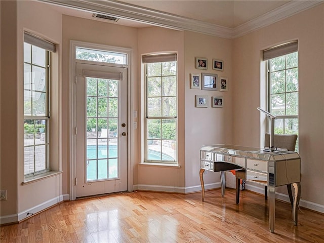 doorway featuring baseboards, light wood finished floors, visible vents, and a healthy amount of sunlight