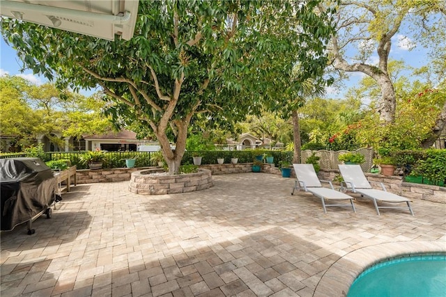 view of patio featuring grilling area and fence