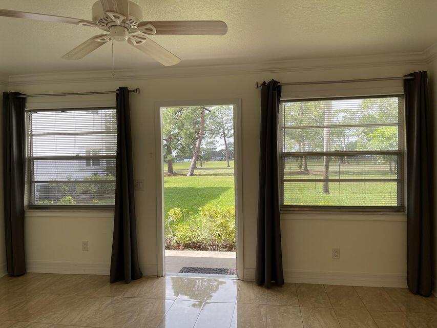 doorway to outside featuring a textured ceiling, baseboards, a wealth of natural light, and crown molding