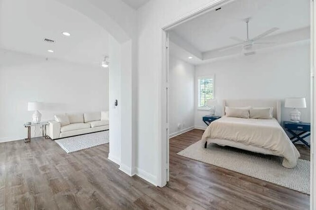 bedroom featuring arched walkways, wood finished floors, visible vents, and recessed lighting