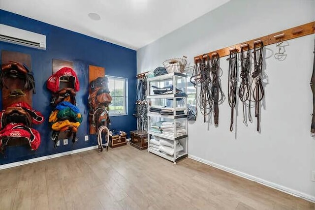 interior space with a wall unit AC and wood finished floors