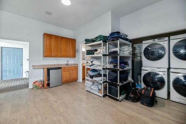 laundry room with light wood-type flooring, laundry area, stacked washer and dryer, and washing machine and clothes dryer