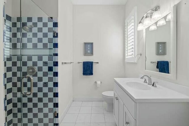 bathroom with tile patterned flooring, toilet, vanity, baseboards, and a shower stall