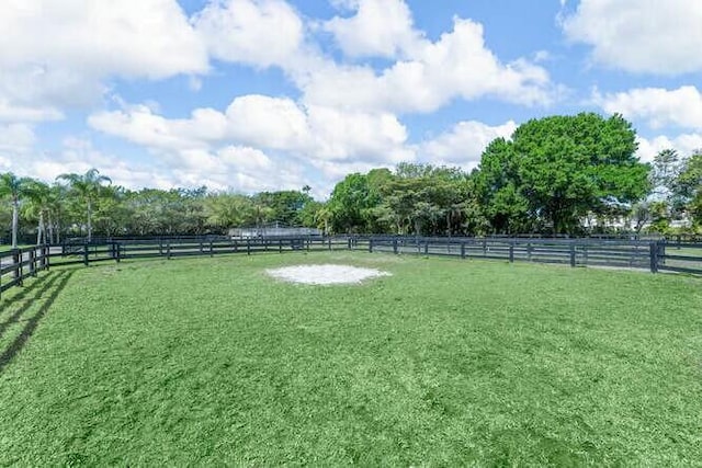 view of yard with fence and a rural view