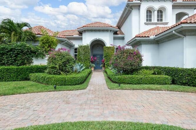 view of front facade with a tile roof and stucco siding