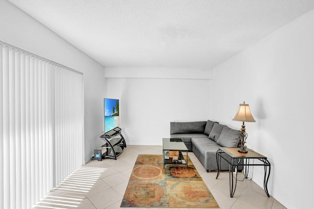 living area featuring a textured ceiling and light tile patterned flooring